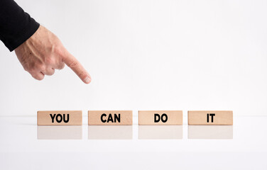 Wall Mural - You can do it. Hand pointing towards the wooden blocks with the message you can do it. Personal motivational inspirational message.
