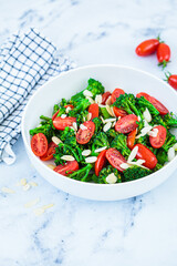 Canvas Print - Broccoli salad with cherry tomatoes and almonds in white bowl. Vegan detox recipe.