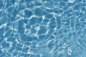 Bluewater waves on the surface ripples blurred. Defocus blurred transparent blue colored clear calm water surface texture with splash and bubbles. Water waves with shining pattern texture background.