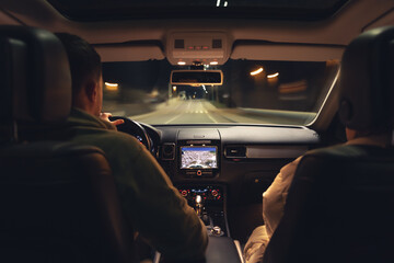 Wall Mural - Man and woman in a car at night, view from the car.