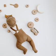 Top View Of Cute One Year Old Baby Plays With Toys. Baby Fashion Concept. Neutral Colors