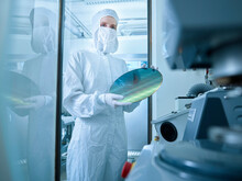 Scientist Holding Wafer Chip Standing In Laboratory