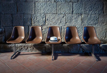 Hat On Empty Brown Seat In Front Of Stone Wall