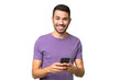 © luismolinero - Young handsome caucasian man over isolated background sending a message with the mobile