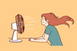 © drawlab19 - Woman sitting in front of fan enjoying cold wind after walking in hot summer weather or doing housework. Sweaty girl cools herself using electric fan due to sudden warming and climate change