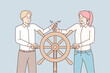 Colleagues steer ship wheel in different directions 