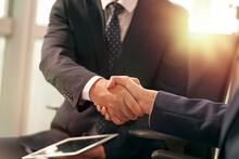 Close-up Shot Of Two Asian Business People Shaking Hands In Office