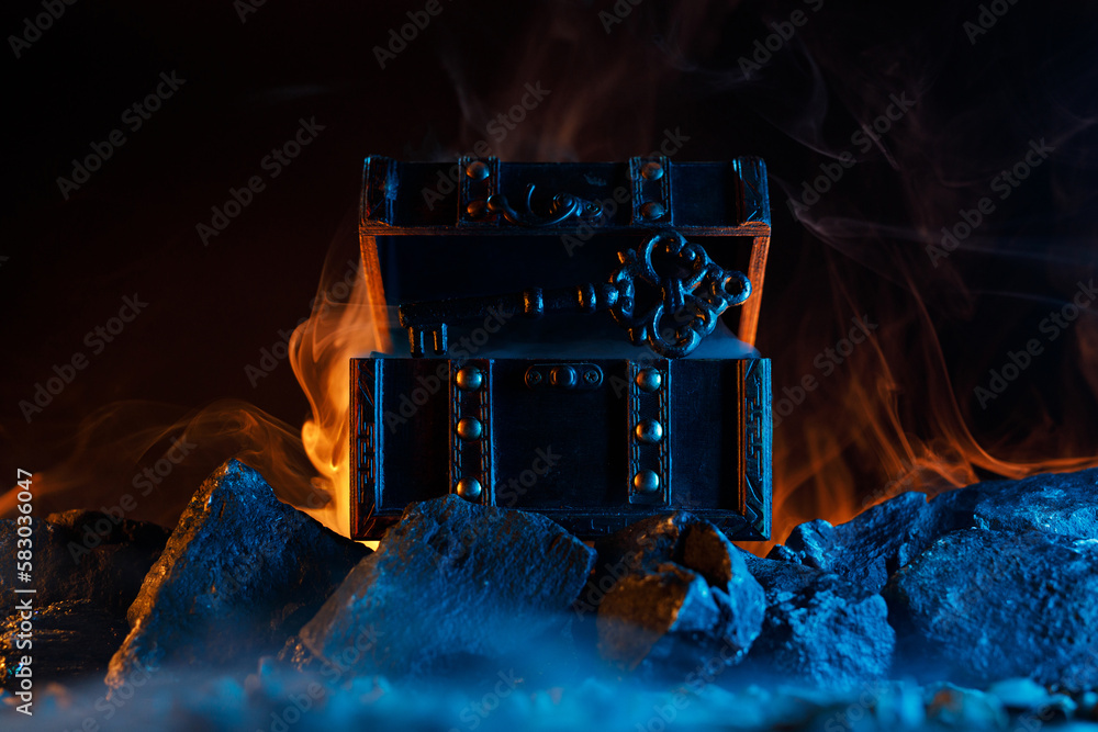 Mystical chest and key on fire on the rocks. Fantastic and fabulous ...
