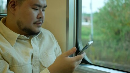 Canvas Print - A man in a commuter train subway metro traveling and uses the smartphone happy tourist travel by train  Freedom trip on vacation time holiday weekend