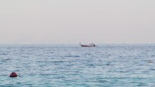 A Lone Local Fisherman Sails His Boat Towards The Shore After Catching Fish In The Morning. In His Hands He Has An Oar With Which He Controls The Boat And Follows The Direction