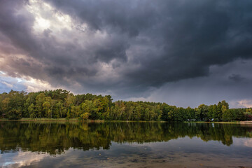 Wall Mural - Natural landscape of the lake, high definition, the movement of waves against the background of the autumn forest. The reflection of clouds on the ripples of water. Germany.