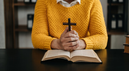 Wall Mural - Hands together in prayer to God along with the bible In the Christian concept and religion, woman pray in the Bible on the wooden table