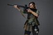 © Fxquadro - Portrait of military woman with rifle looking to side isolated on grey background.