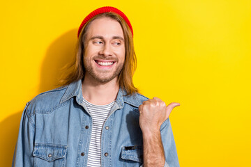 Wall Mural - Portrait of cheerful positive man with bob haircut wear denim jacket looks directing at empty space isolated on yellow color background