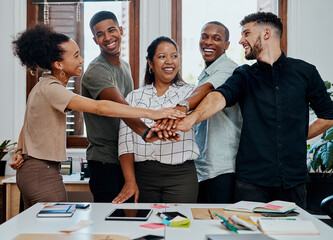 Poster - Success is up to all of us. a group of young businesspeople joining hands during a meeting in a modern office.