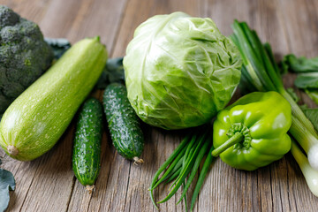Wall Mural - Green raw vegetables on wooden background. Healthy organic food.