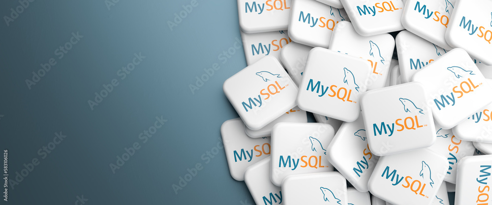 Logos of the open source database system MySQL on a heap on a table ...