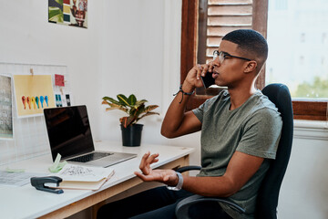 Wall Mural - We may have to extend the deadline on that. a young businessman using a smartphone in a modern office.