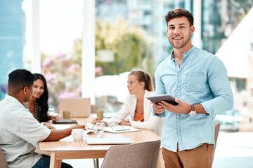 Poster - Glad you made it. Cropped portrait of a handsome young businessman using his tablet while standing in the boardroom during a meeting.