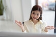 © Natee Meepian - Portrait of happy smiling female customer support phone operator at workplace. Smiling beautiful Asian woman working in call center