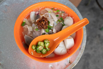 A bowl of Chinese noodle broth that is popular in Penang, Malaysia. The dish consists of flat rice noodles served with a clear savoury broth