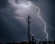 Lightning striking above a transmission tower on a dark gloomy and cloudy evening