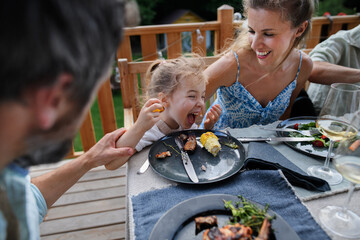 Wall Mural - Family eating at barbecue party dinner on patio,having fun and enjoying it.