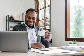 Wall Mural - Success at work, good deal. African-American guy looks at the laptop screen, screams excitedly and raises his fists in a victory gesture at home