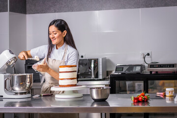 colombian pastry chef smiling preparing her cake. happy work