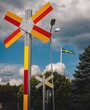 Closeup of an red and yellow railroad crossing sign against a cloudy sky