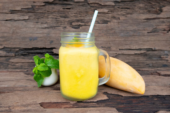 Fototapete - Orange juice fruit smoothies yogurt drink yellow healthy delicious taste in a glass slush for weight loss on wooden background.