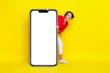 Full Body Portrait Of Charming Positive Lady Peeking Behind Empty Space Billboard Isolated On Yellow Color Background