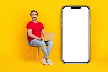 Poster - Photo of cute cheerful guy pensioner dressed red t-shirt glasses writing gadget empty space isolated yellow color background