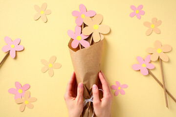 Bouquet of flowers from paper in the hands of mom. Mothers Day holiday concept