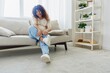 © SHOTPRIME STUDIO - Pregnant woman sitting on the couch at home and wearing comfortable shoes for pregnancy with a problem due to the stomach, headache, pregnancy and motherhood difficulties, severe fatigue