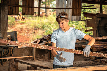 young man working in a wood yard.