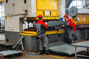 Wall Mural - Technician operators working with with sheet metal on CNC hydraulic press brake