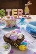 Easter table setting with painted eggs. Easter cake and cutlery on the festive table