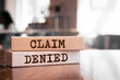 Wooden blocks with words 'CLAIM DENIED'. Business concept
