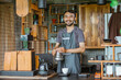 © Odua Images - male barista in apron standing with smile while brewing the coffee inside the bar desk