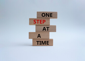 Wall Mural - One step at a time symbol. Concept words One step at a time on wooden blocks. Beautiful white background. Business and One step at a time concept. Copy space.
