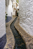 Fototapeta Na drzwi - street of a town in the Alpujarra of Granada with water running through a canal in the center of the road