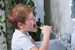 © Оксана Рязанова - Boy brushes his teeth and oral cavity with irrigator in the bathroom. Hygiene and healthy lifestyle concept