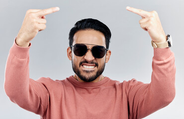 Wall Mural - Portrait, rude and man with anger, middle finger and frustrated against grey studio background. Face, male and guy with offensive hand gesture, aggressive and conflict with expression and disrespect