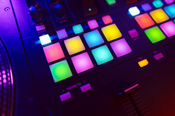 Wall Mural - Close up of DJ mixing console in party light