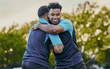 © Delcio/peopleimages.com - Man, friends and hug in sports for partnership, teamwork or trust in unity for game or match in nature. Happy men hugging in sport practice, rugby or workout exercise in team training outdoors