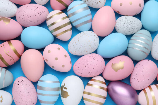 Wall Mural - Many painted Easter eggs on blue background, flat lay