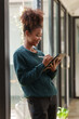 © amnaj - Woman student holding tablet preparing for online class.
