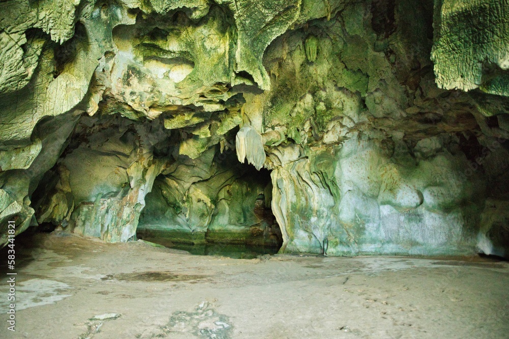A limestone cave in Coron, Palawan in the Philippines with impressive rock formations on the ceiling and a lake in the cave.
