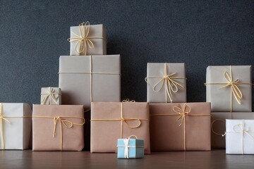 Sticker - Craft Christmas gift boxes stack on dark background on wooden table., created with generative ai